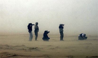 Varios reporteros toman fotografías en presencia de 'marines' estadounidenses en el desierto de Kuwait.