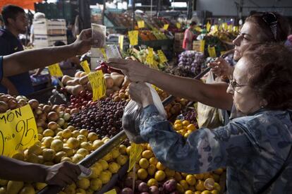 Dos mujeres pagan con billetes de baja denominaci&oacute;n en el Mercado Central.