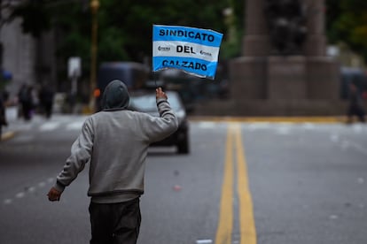 Un trabajador miembro del Sindicato del Calzado ondea una bandera al fin de jornada de protestas en conmemoración del Día Internacional del Trabajador, en Buenos Aires.