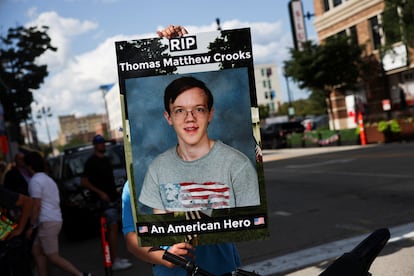 Un hombre sostiene una pancarta con la foto de estudiante de Thomas Crooks en las inmediaciones de la Convención Nacional Republicana, en Milwaukee.