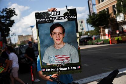 Un hombre sostiene una pancarta con la foto de estudiante de Thomas Crooks en las inmediaciones de la Convención Nacional Republicana, en Milwaukee.