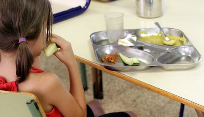 Una nena esmorza en un menjador escolar.