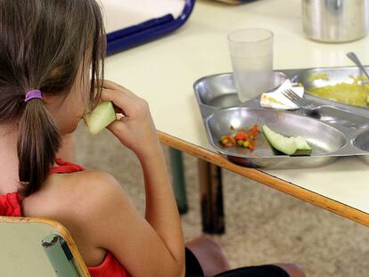 Una ni&ntilde;a almuerza en un comedor escolar