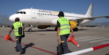 Dos operarios se dirigen a un avión en el aeropuerto de Granada.