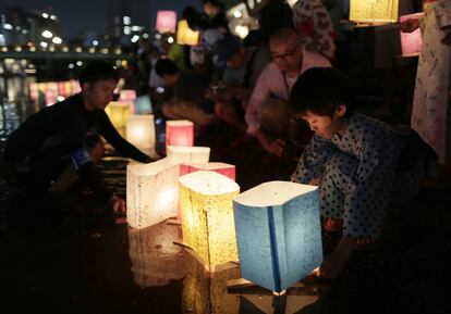 Un niño deposita una linterna de papel en el río durante el 71 aniversario conmemorativo de la bomba atómica de Hiroshimaen el Parque Memorial de la Paz de Hiroshima (Japón).