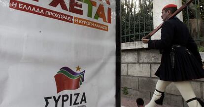 Un guardia presidencial pasa al lado de un cartel del partido griego izquierdista Syriza