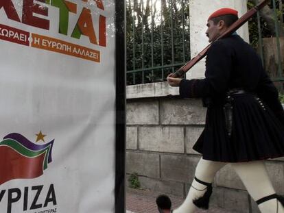 Un guardia presidencial pasa al lado de un cartel del partido griego izquierdista Syriza