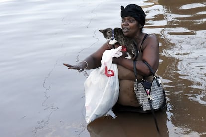 Una mujer lleva un gato y sus pertenencias a través del agua de una inundación en Manville, Nueva Jersey.
