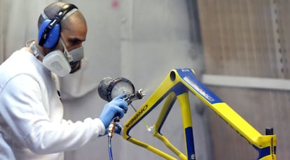 Un trabajador pinta un cuadro de una bicicleta de Orbea.