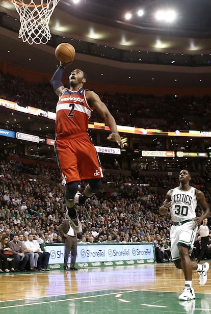 John Wall, de los Washington Wizards, machaca el aro ante Brandon Bass, de Boston