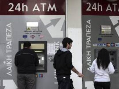 Varias personas sacan dinero de un cajero de Nicosia, Chipre. EFE/Archivo