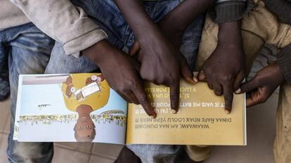 Niños acogidos en el centro La Maison de la Gare, miran el libro 'Solo la vida'.