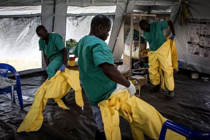 Un equipo de trabajadores médicos se visten con su equipo de protección personal (EPP) antes de entrar en un centro de tratamiento del ébola dirigido por la Alianza para la Acción Médica Internacional (ALIMA) el 11 de agosto de 2018 en Beni, noreste de la República Democrática del Congo. El conflicto que vive el país está obstaculizando los esfuerzos para frenar el brote de esta enfermedad.