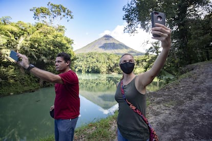 Turistas toman fotografías con el volcán Arenal de fondo en la zona de la Fortuna de San Carlos el pasado agosto, al norte de San José (Costa Rica).