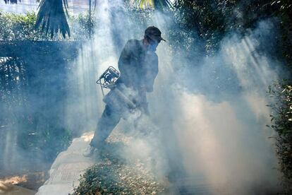 Un trabajador rocía insecticida para mosquitos en una aldea en Bangkok (Tailandia).