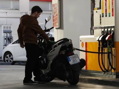 Un motorista reposta en una estaci&oacute;n de servicio.