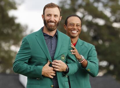 Dustin Johnson con la chaqueta verde que le entrega Tiger Woods.