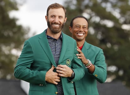 Dustin Johnson con la chaqueta verde que le entrega Tiger Woods.