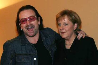 Ángela Merkel y el cantante irlandés Bono, ayer en el Foro Económico Mundial.