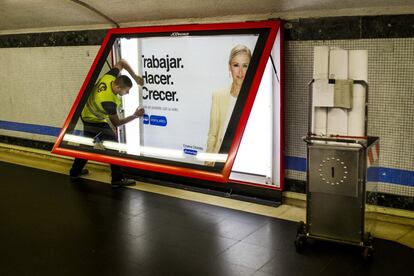 Un trabajador retira una publicidad electoral del PP en Madrid horas antes del cierre de campaña.