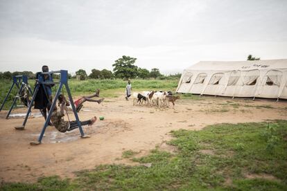 Columpios sobre un trozo de red en el campo de desplazados. Medio centenar de familias viven en este lugar en casetas improvisadas.