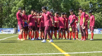 Los futbolistas del sub-15 chino escuchan atentos las instrucciones de uno de los intérpretes de la Asociación China de Fútbol.