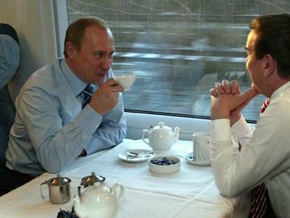Vladímir Putin (izquierda) charla con Gerhard Schröder a bordo de un tren de alta velocidad, en diciembre de 2004.