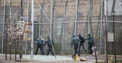 Spanish Civil Guard officers march two immigrants back to Morocco on February 19.