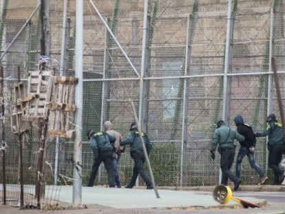 Spanish Civil Guard officers march two immigrants back to Morocco on February 19.