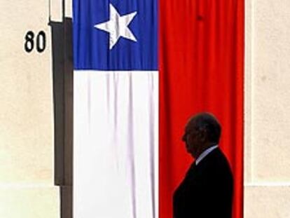 Lagos, frente a la puerta de La Moneda, cubierta con una bandera chilena.