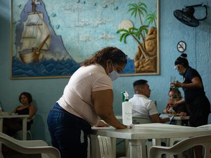 Una mujer limpia la mesa de un restaurante en Acapulco.