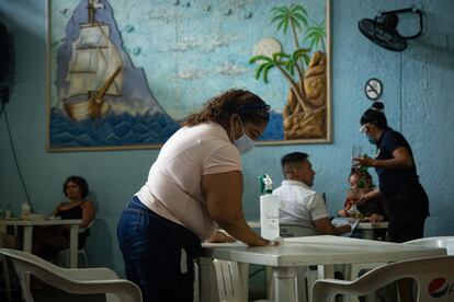 Una mujer limpia la mesa de un restaurante en Acapulco.