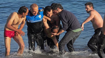 Agentes de la Policía Local retiran del agua al hombre de origen argelino, de 42 años de edad, que falleció tras ser rescatado esta mañana inconsciente de la playa del Orzán, en La Coruña, donde se había celebrado la noche de San Juan.