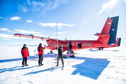 El glaciólogo Ricardo Jaña clava una vara de bambú en la mayor plataforma de hielo del mundo, la de Filchner-Ronne, escoltado por los exploradores militares, Inmortal y Prometeo.