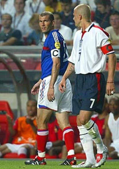 Zidane y Beckham se cruzan durante el partido.