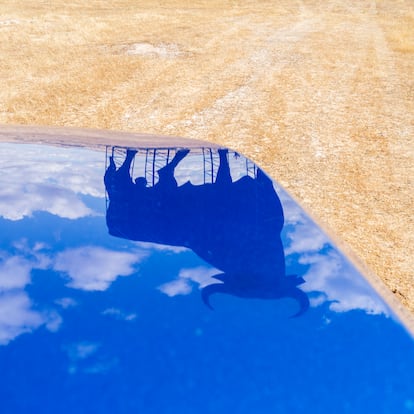 Un toro de Osborne se refleja en la carrocería del coche. Afueras de Salamanca. 