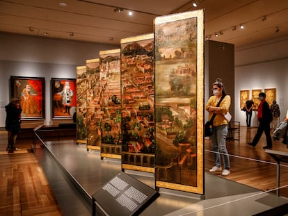 Varios visitantes observan 'Obrador de los Correa’, un biombo que forma parte de la exposición ‘Tornaviaje: Arte iberoamericano en España’, en el Museo del Prado.