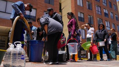 Personas reciben su ración de agua en edificios residenciales de La Calera, a las afueras de Bogotá, el 16 de abirl.