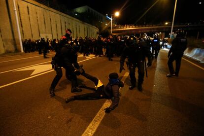 Un agent de Mossos retira un manifestant que bloqueja una carretera d'accés a Barcelona.