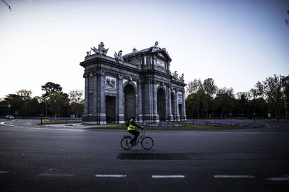 Un ciclista pasa cerca de la Puerta de Alcalá, esta mañana en Madrid. 