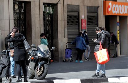 Varias personas guardan cola para realizar la compra en un supermercado en Valencia.