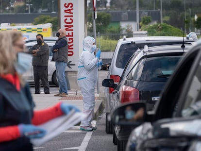 Un sanitario realiza pruebas PCR a personas que se acercan a un centro de salud en Coria del Río (Sevilla) en sus coches.