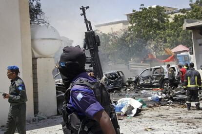 Las fuerzas de seguridad somalíes vigilan la zona en la que un coche bomba ha explotado, en Mogadiscio.