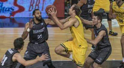 Carmichael y el alero del Gran Canaria, Brad Newley pelean por un balón.