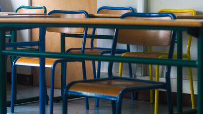 Una hilera de sillas en un aula vacía.