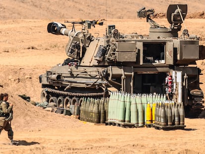 Una soldado israelí pasaba el miércoles junto a un obús autopropulsado M109, en un lugar no revelado en Israel cerca de la frontera con Gaza.