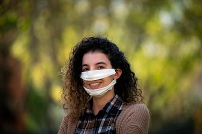 La diseñadora francesa Anissa Mekrabech, con problemas auditivos, posa con la mascarilla que ha diseñado y lleva hasta una ministra.