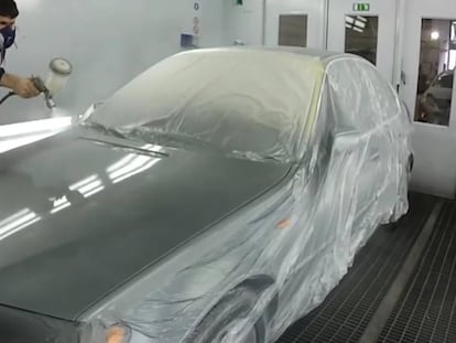 Un operario pintando un coche.