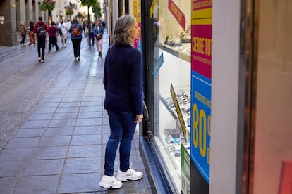 Una mujer observa un escaparate en una calle del centro de Granada.