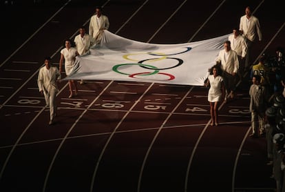 Diversos membres de l'organització porten la bandera olímpica.